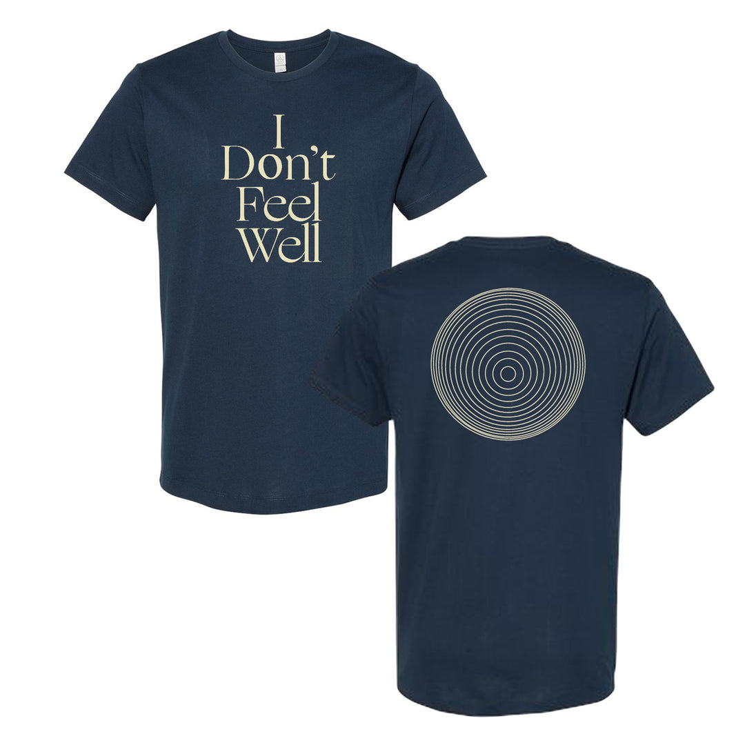image of the front and back of a midnight navy tee shirt on a white background. front of the tee is on the right and has a center print of cream colored stacked text that says I don't feel well. the back of the tee is on the right and has a circle in the center